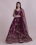 Women wearing a wine-colored taffeta silk lehenga choli with intricate embroidery.