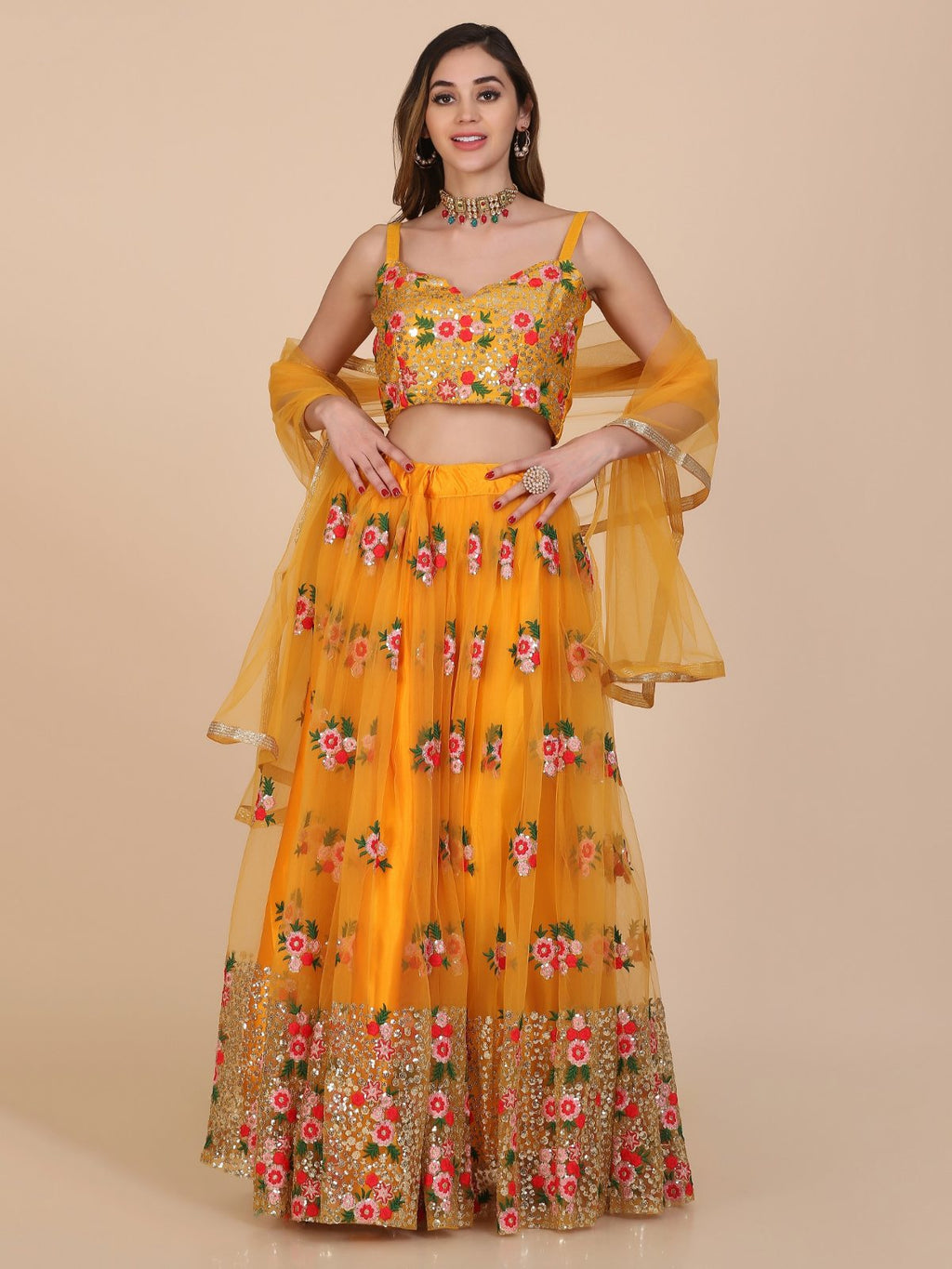 Women in a vibrant yellow net lehenga choli featuring intricate thread work.