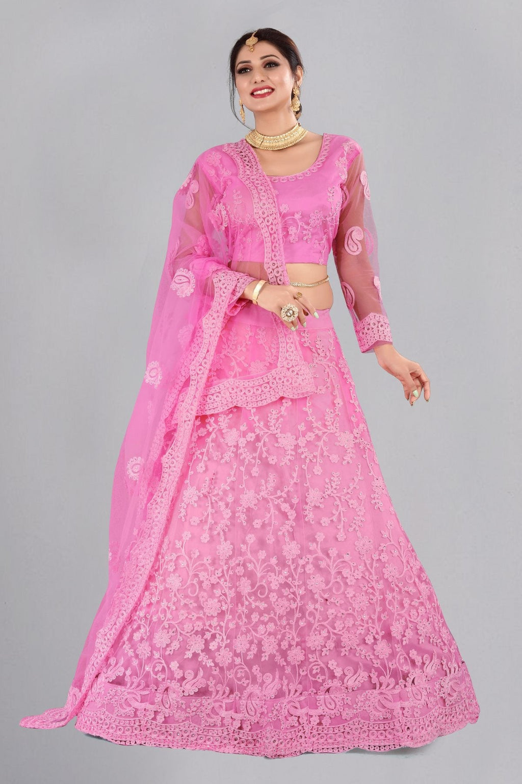 Baby girl wearing a baby pink net lehenga choli with intricate thread embroidery