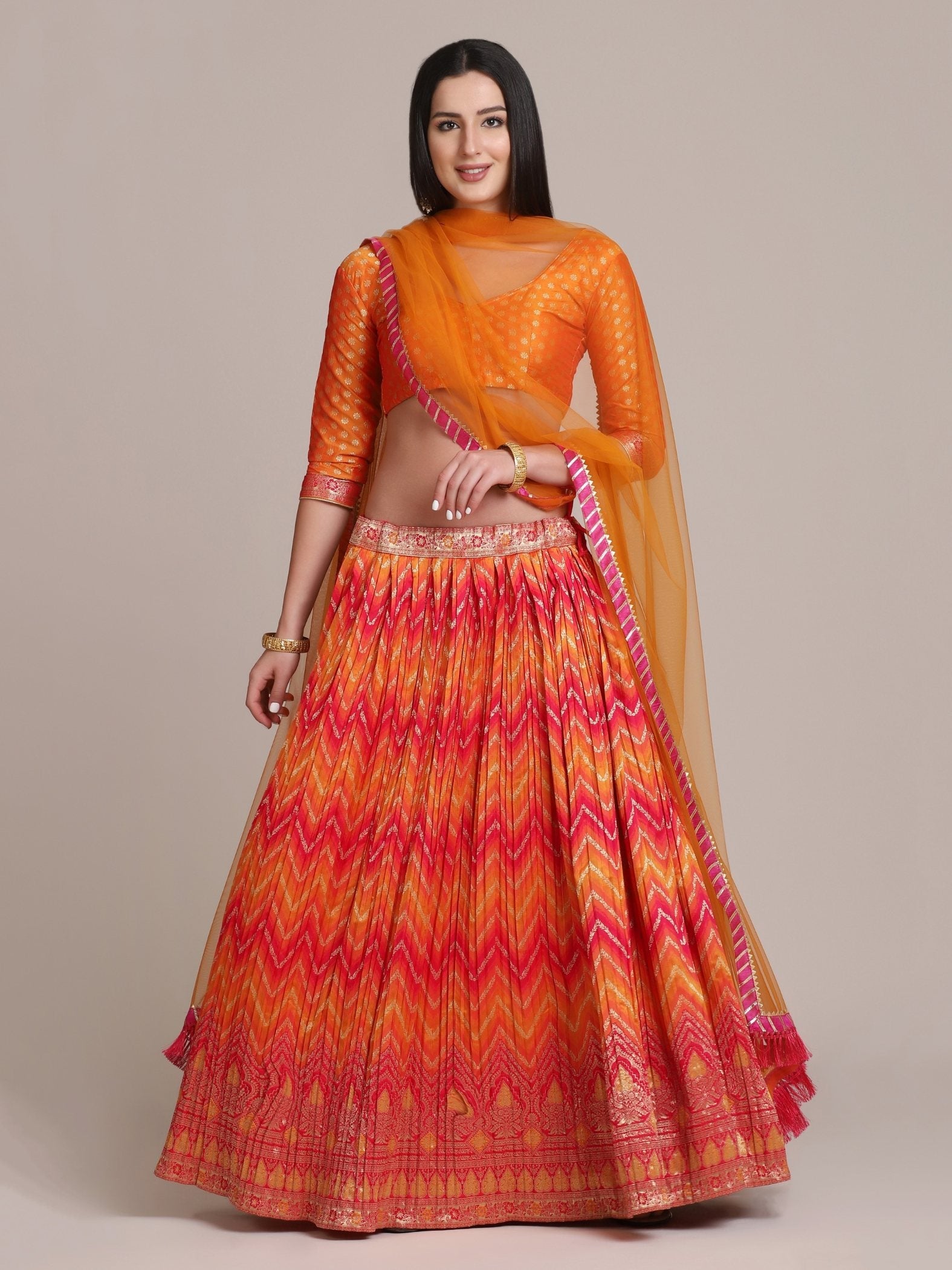 Orange silk blend lehenga choli with traditional zari woven patterns