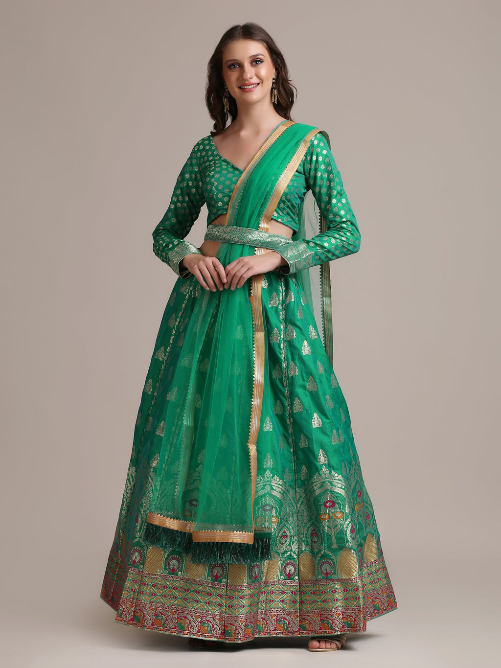 Woman wearing a Rama colored Jacquard Silk Lehenga Choli with gold woven work.
