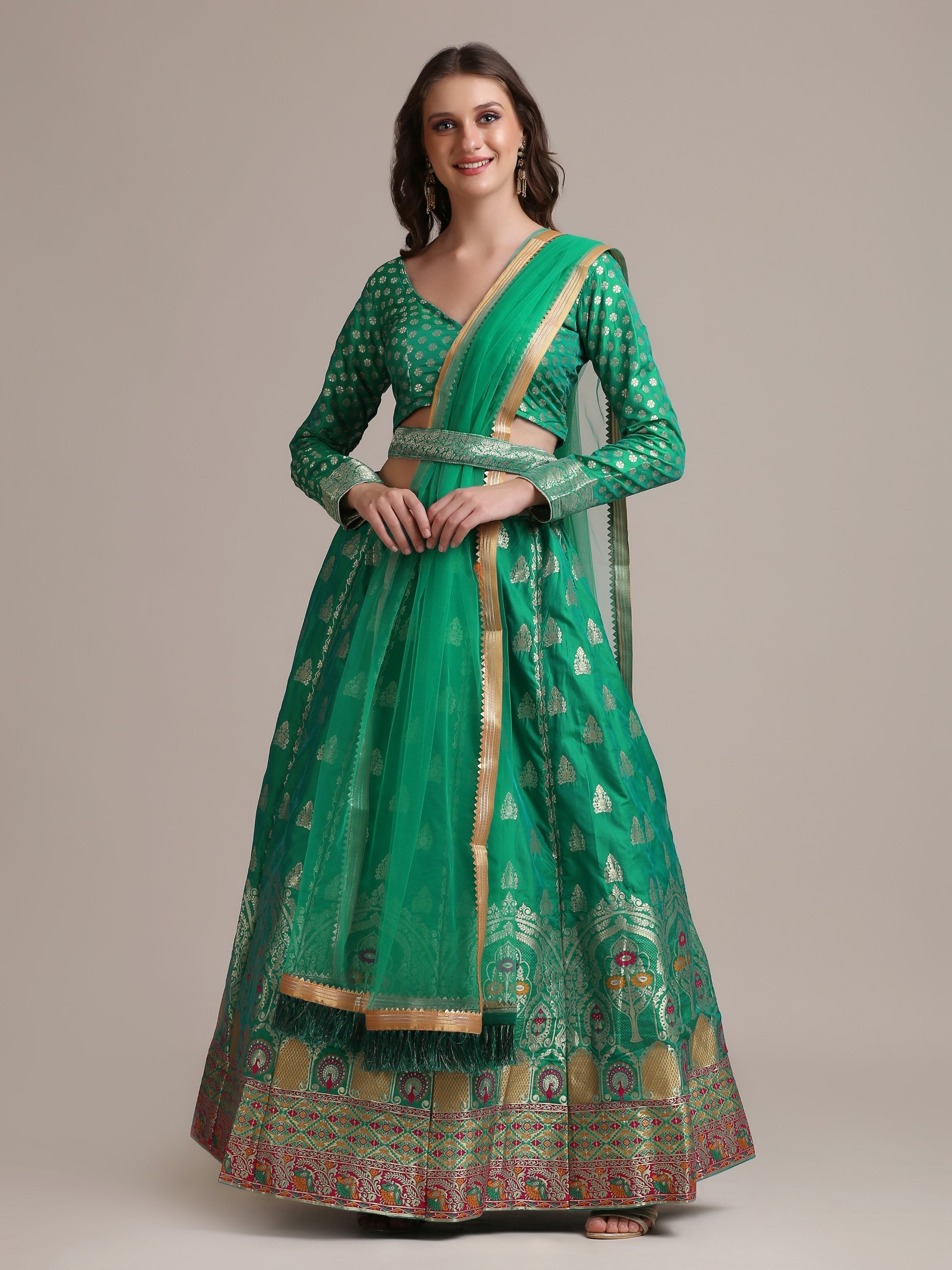 Woman wearing a Rama colored Jacquard Silk Lehenga Choli with gold woven work.