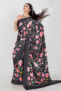 A beautiful Japan Satin saree featuring vibrant floral digital prints in black, pink, and green with a matching blouse.