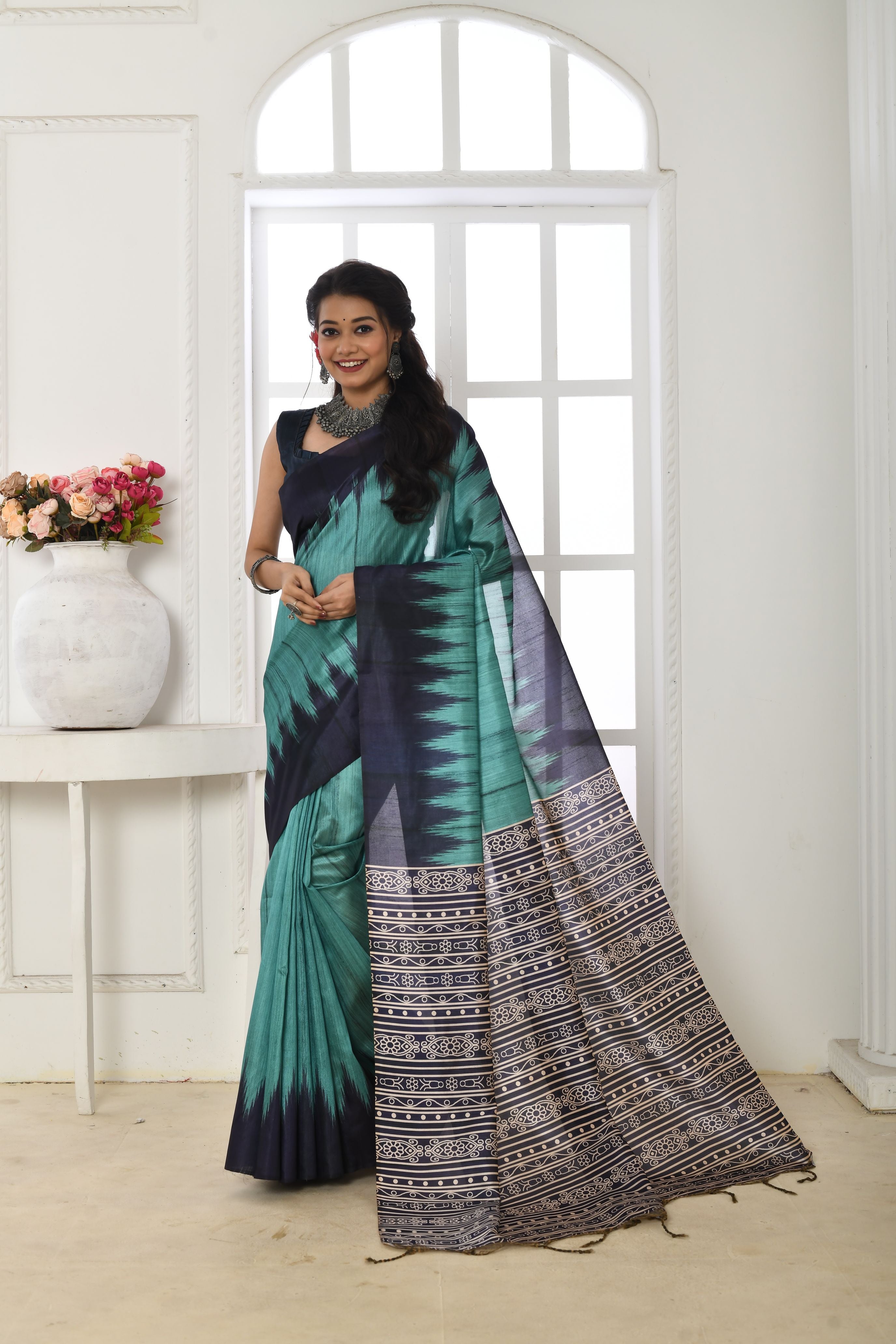 Firozi soft Tussar silk saree with a traditional printed temple border and matching blouse piece.