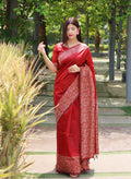 Vibrant red handloom raw silk saree with a printed border and matching blouse piece.