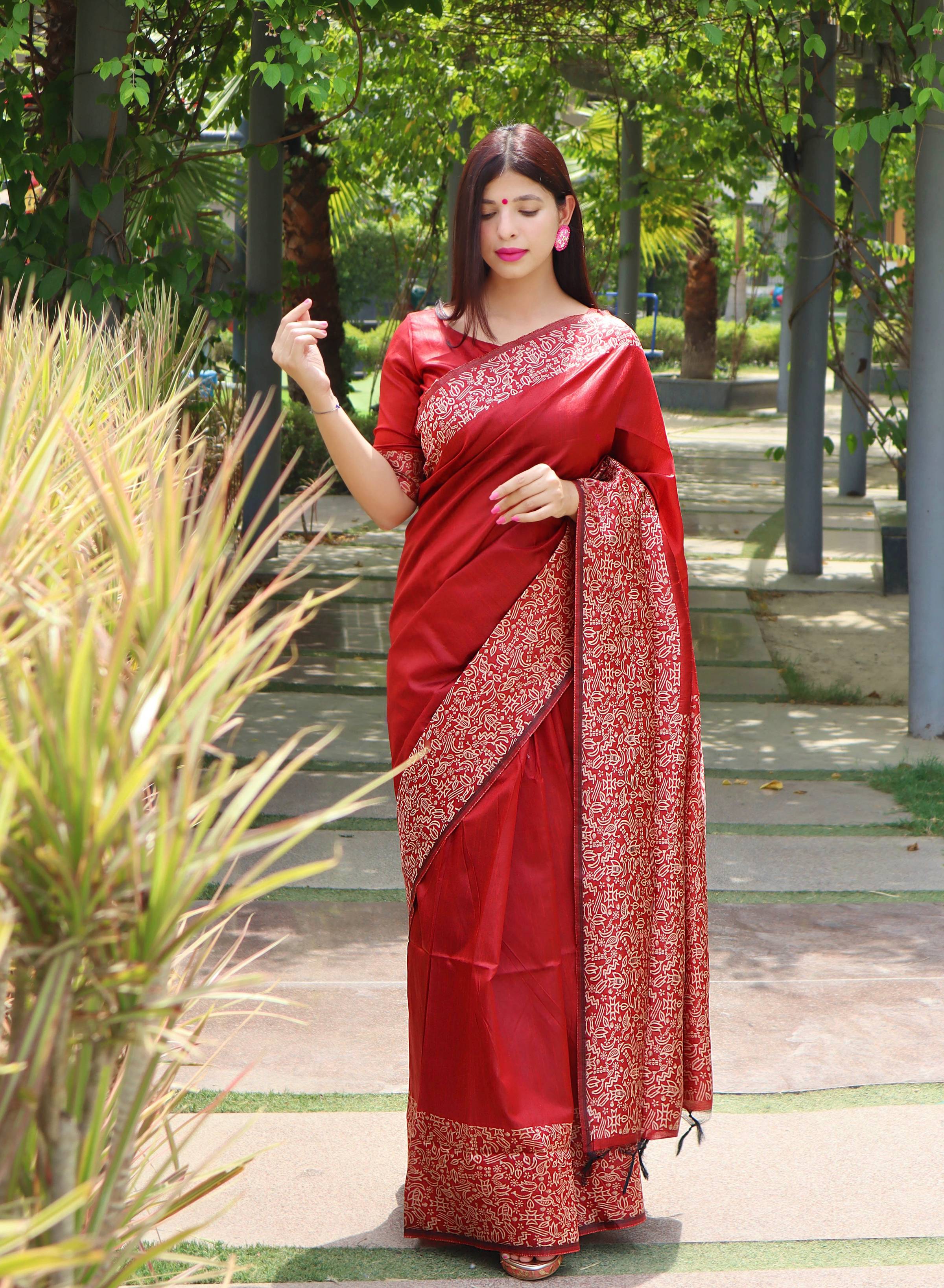 Vibrant red handloom raw silk saree with a printed border and matching blouse piece.