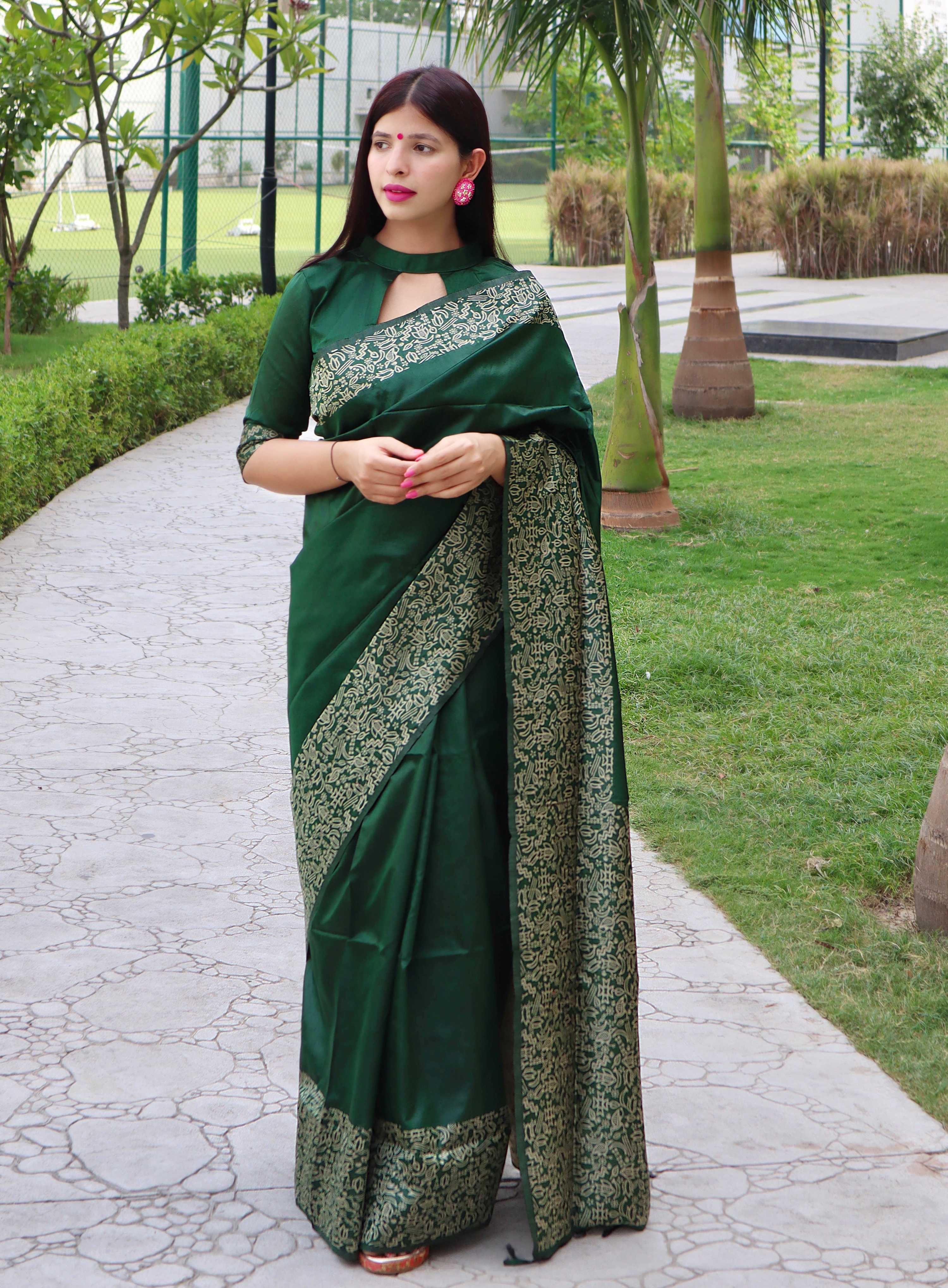 Woman wearing a Green Handloom Raw Silk Saree with a printed border and matching blouse.