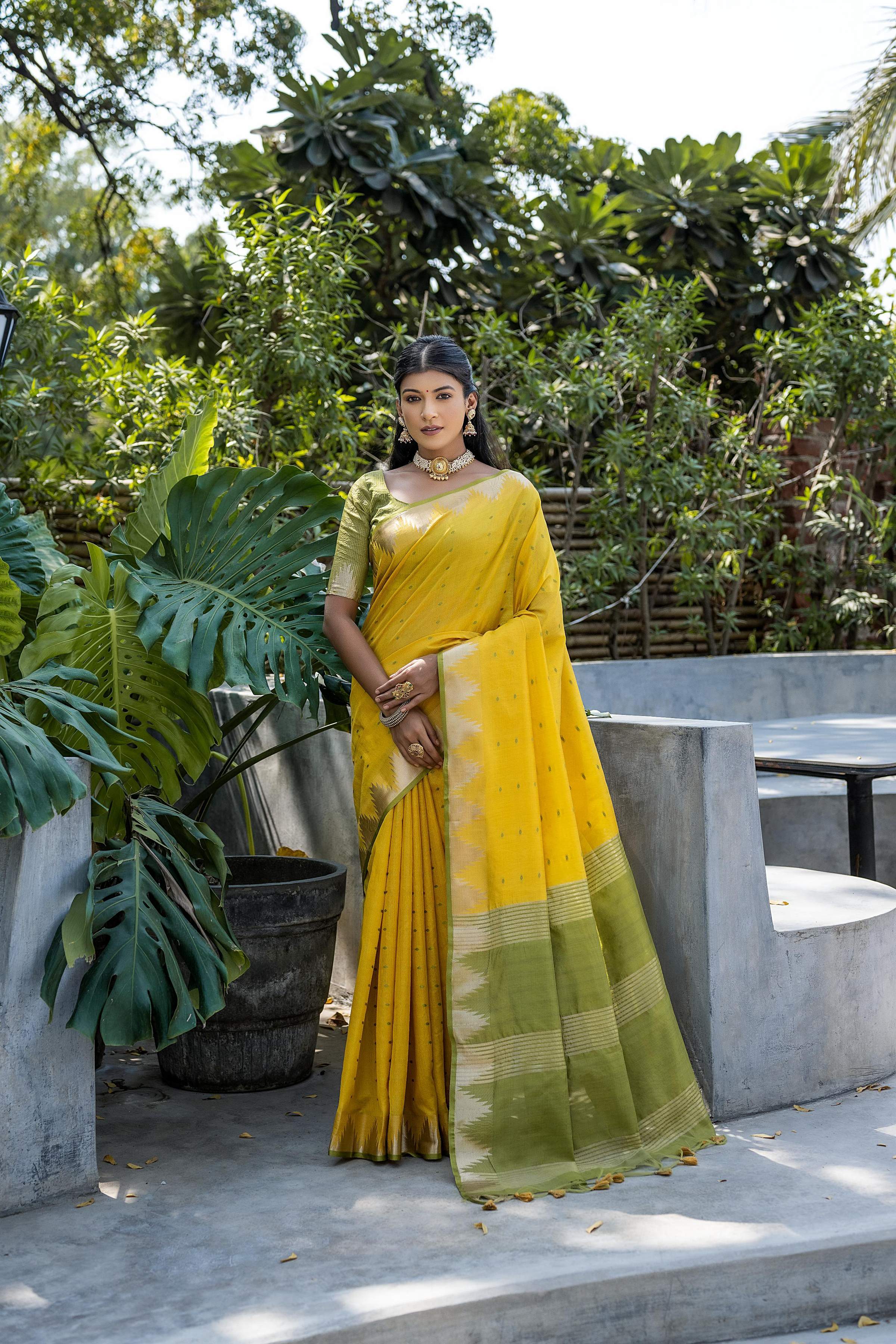 Bright yellow semi Tussar silk saree with a detailed temple border