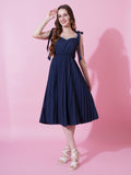 Woman wearing a Navy Blue sleeveless crushed crepe flared dress with shoulder tie-ups.