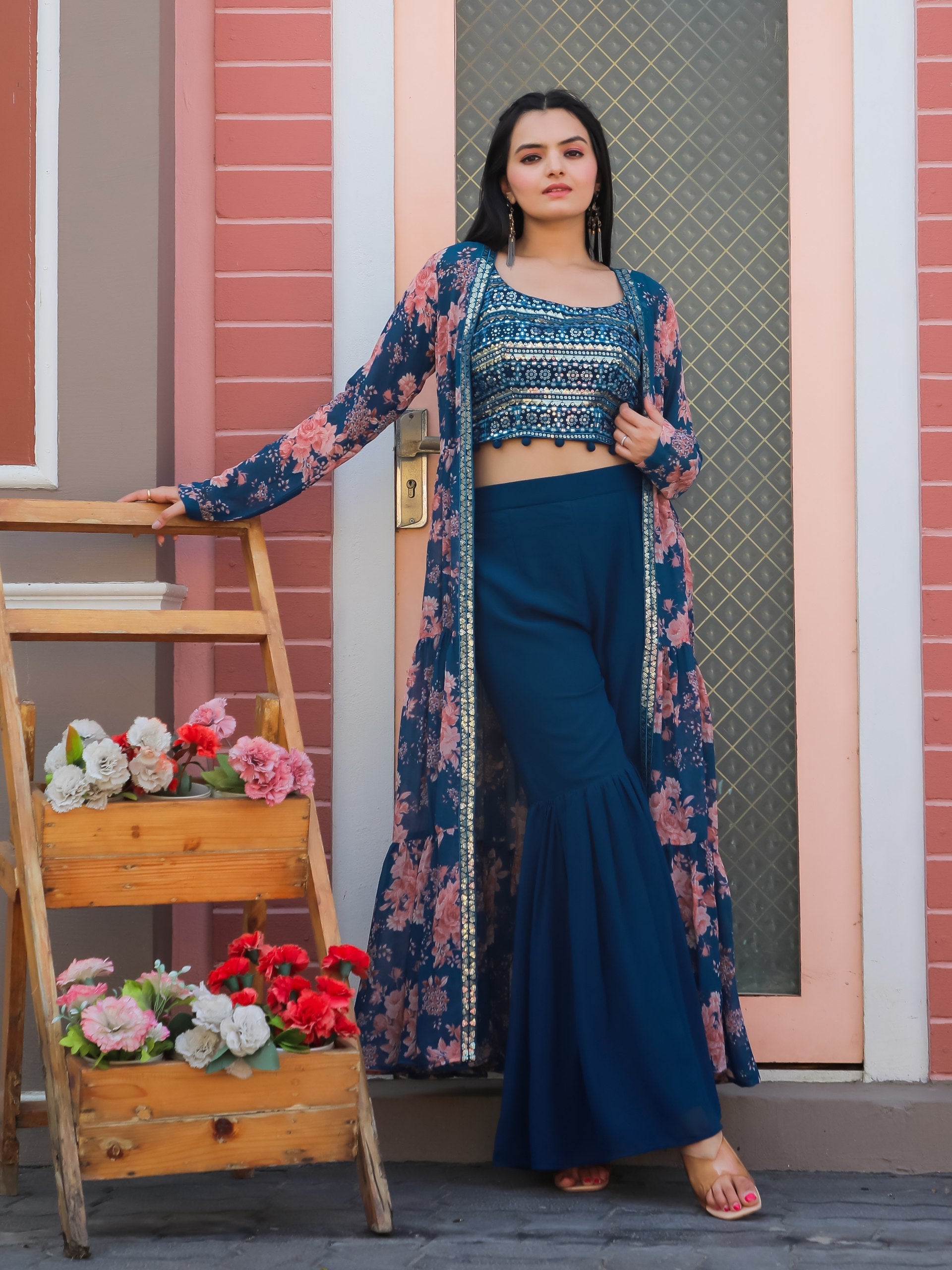 Woman wearing a Teal Blue Georgette Sharara set with sequin choli and printed shrug