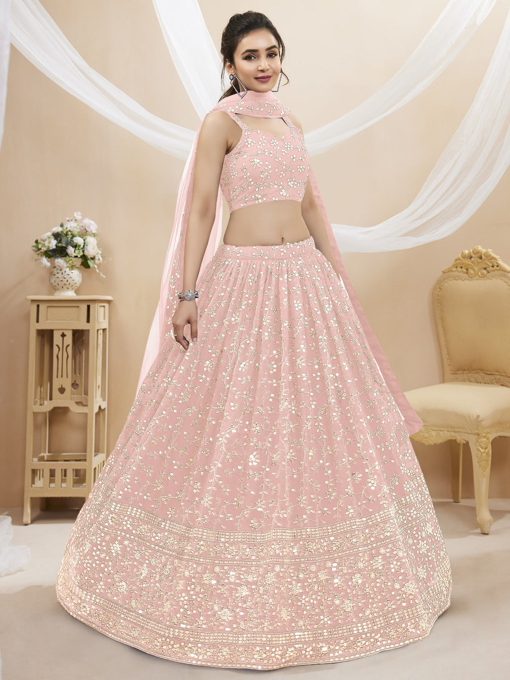 Girl wearing a baby pink georgette lehenga choli with sequins and zari embroidery
