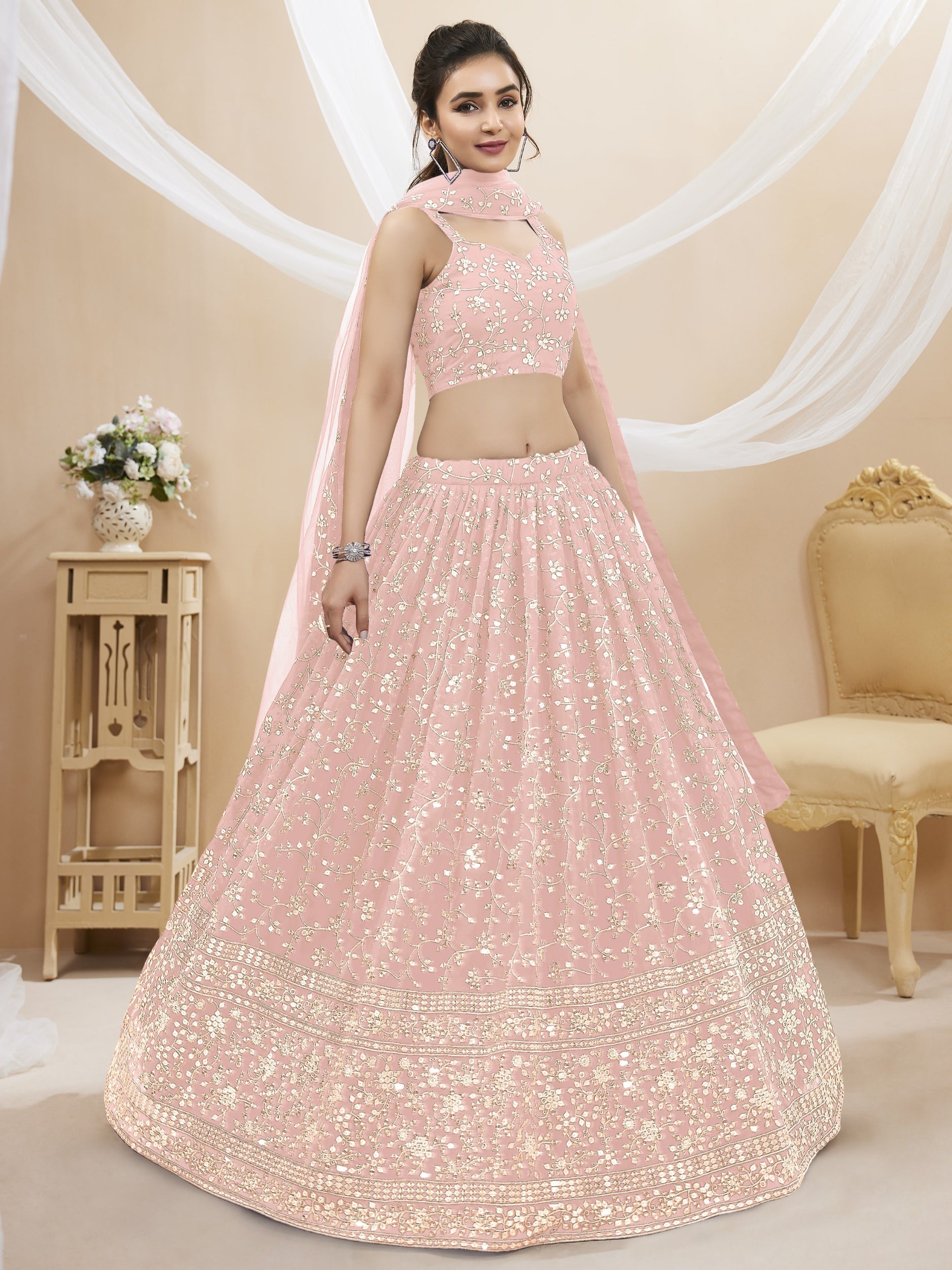 Girl wearing a baby pink georgette lehenga choli with sequins and zari embroidery
