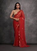 Red Chiffon designer saree featuring detailed mirror work and an unstitched blouse piece.