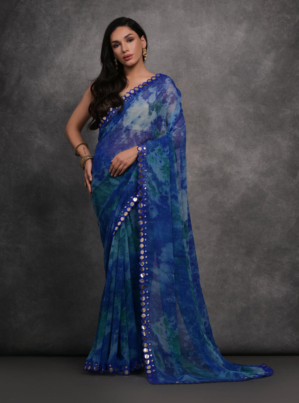 Blue printed chiffon saree with mirror work accents and matching blouse piece