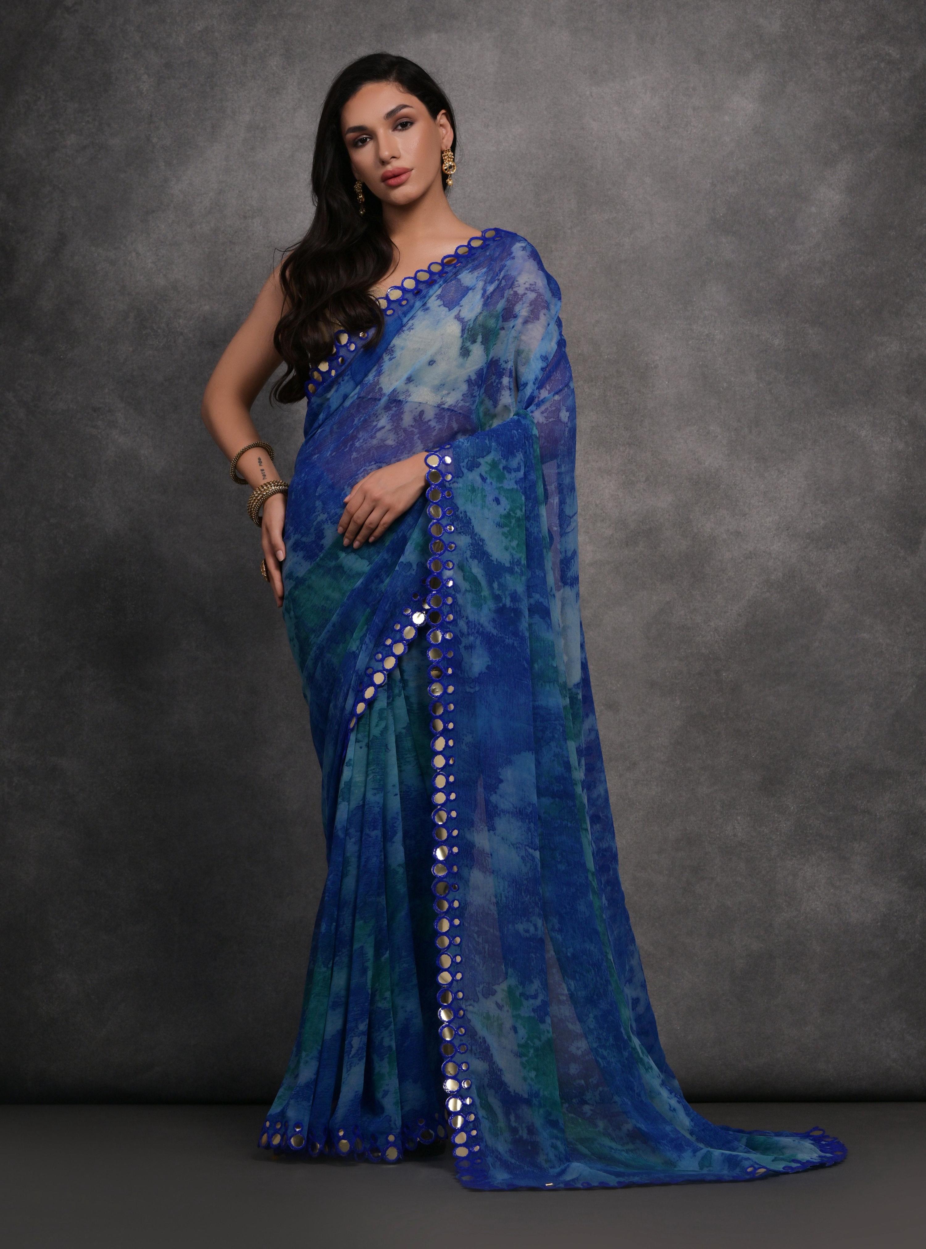 Blue printed chiffon saree with mirror work accents and matching blouse piece