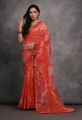 Vibrant red chiffon designer saree featuring prints and traditional mirror work