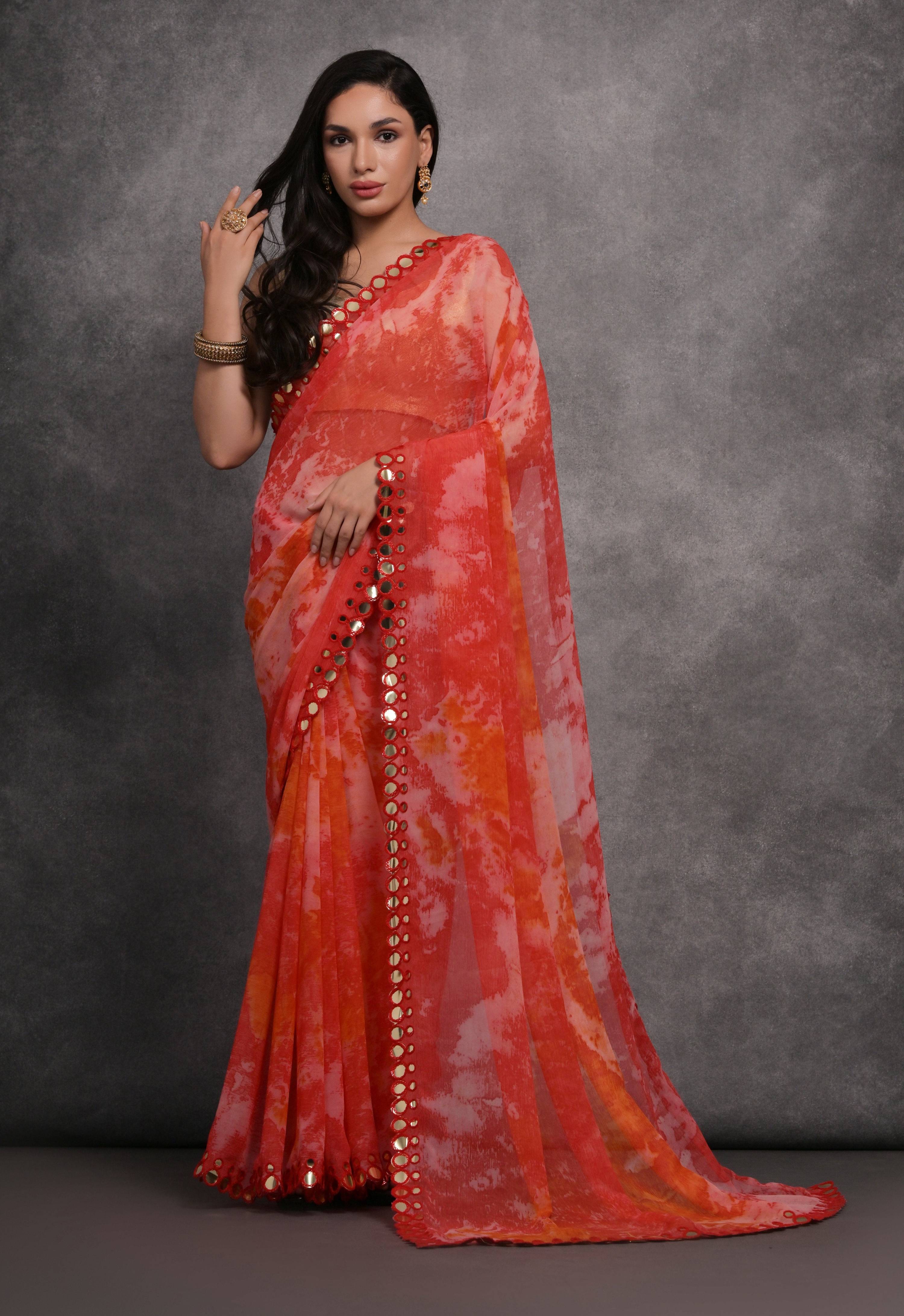 Vibrant red chiffon designer saree featuring prints and traditional mirror work