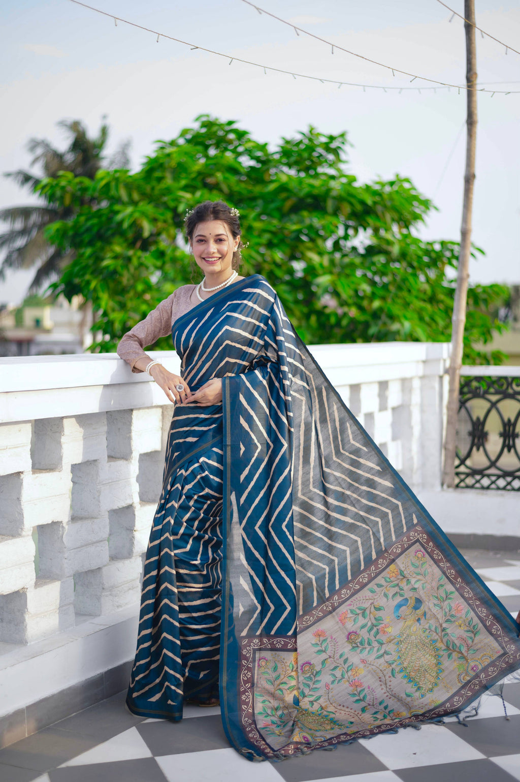 Blue Tussar silk saree featuring a Leheriya print and a decorative zari border with a matching blouse piece