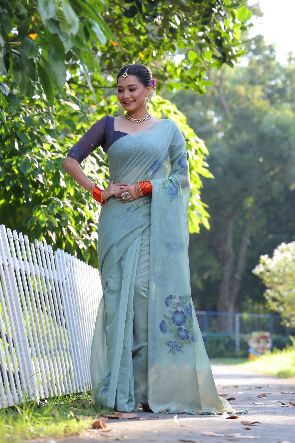 Elegant sky blue Muga cotton Jamdani saree with intricate weaving and a navy blue unstitched blouse.