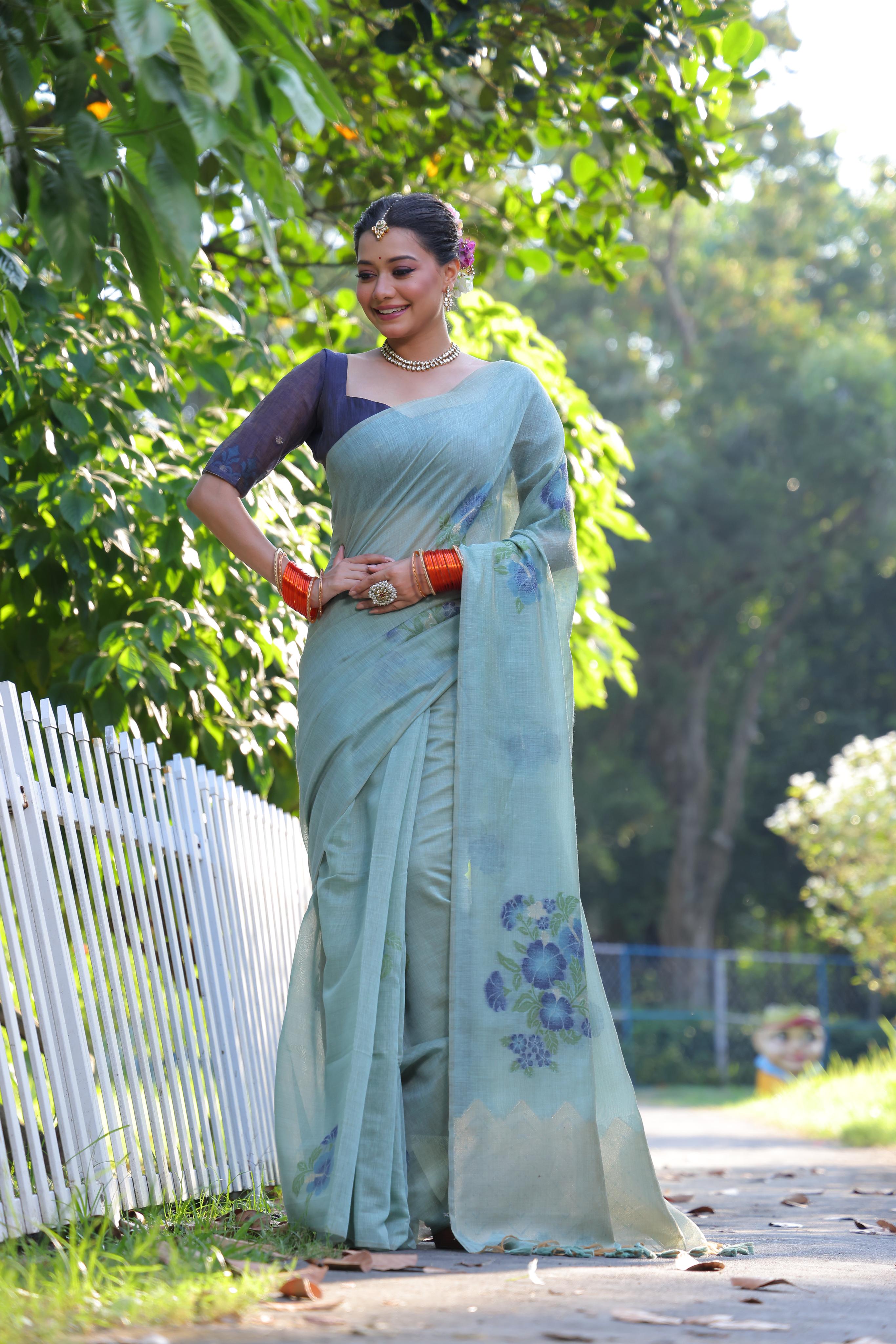 Elegant sky blue Muga cotton Jamdani saree with intricate weaving and a navy blue unstitched blouse.