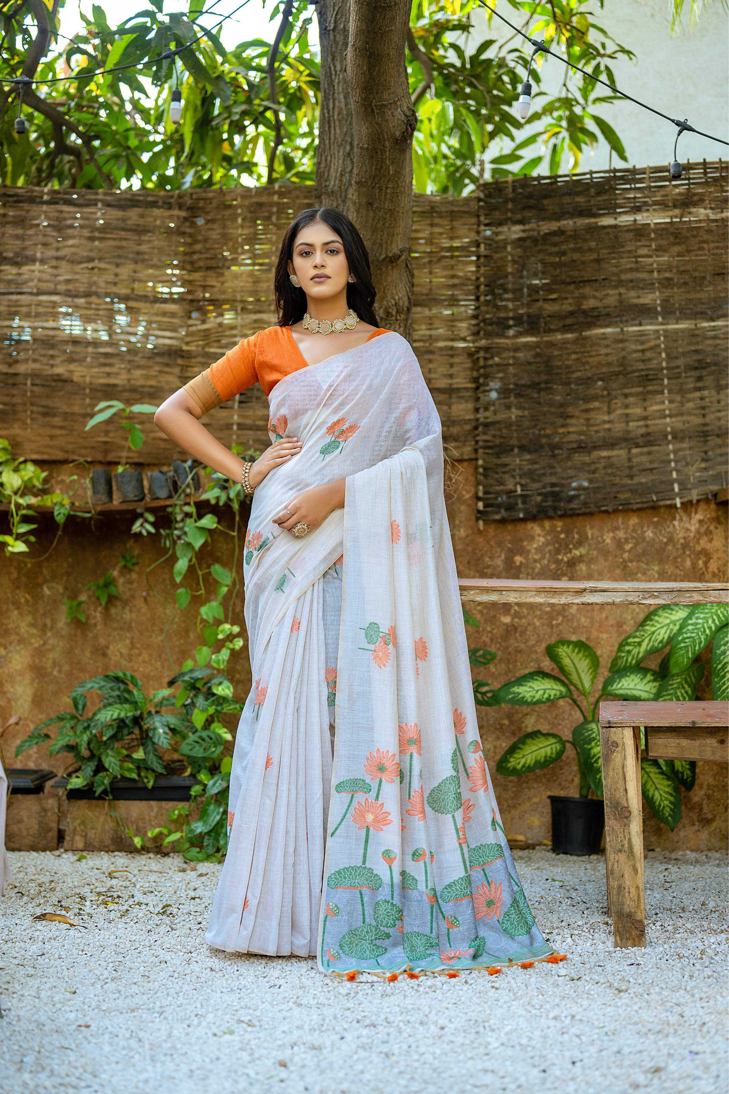 Orange soft Muga cotton saree featuring intricate floral weaving and a matching blouse.