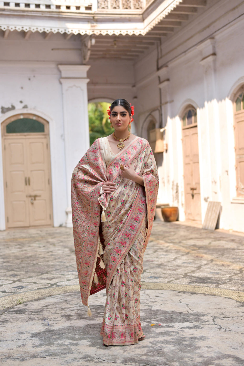 Elegant cream soft pashmina silk saree with detailed meena zari weaving and matching blouse.