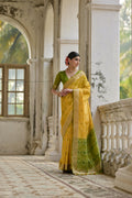 Yellow soft raw silk saree with intricate Zari woven patterns and matching blouse.