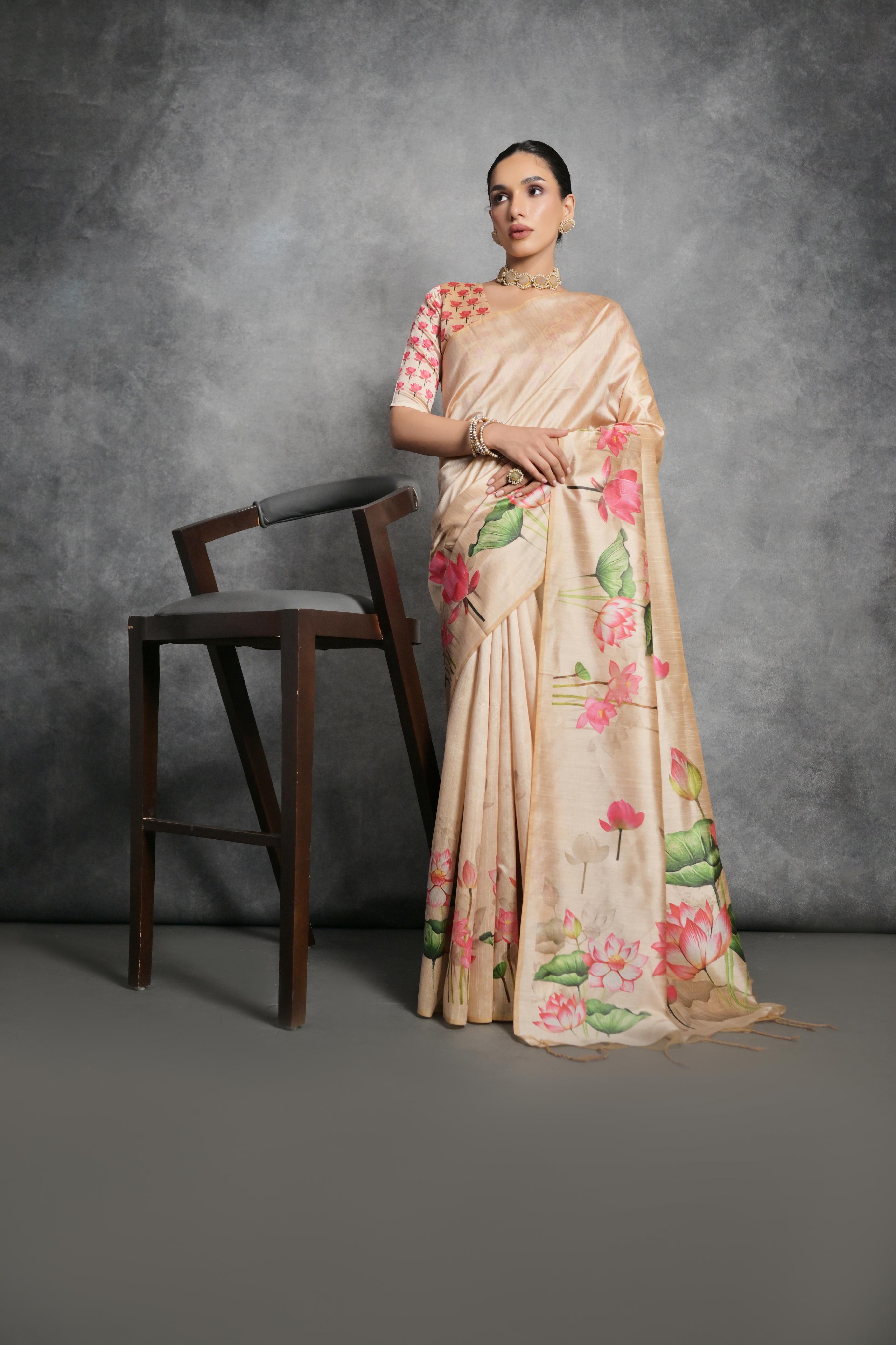 Woman wearing a cream soft tussar silk saree with floral print and matching blouse