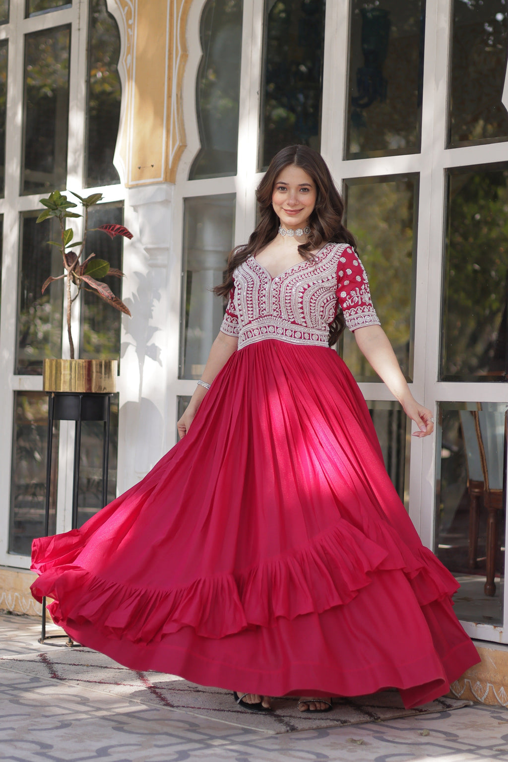 Woman wearing a pink star georgette Anarkali set with intricate sequins embroidery and center slit
