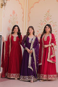 Woman wearing a maroon, purple, and rani Faux Blooming Anarkali set with sequin and zari embroidery.