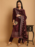 Woman wearing a maroon velvet straight kurta with floral Resham, Jari, and sequin work paired with matching trousers.