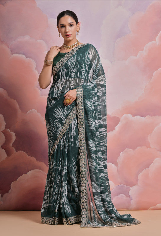 Dark green georgette saree with abstract pattern, zari coding, and sequence embroidery.