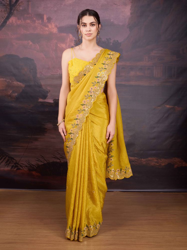 Woman wearing a yellow art silk designer saree with detailed sequins embroidery and matching blouse
