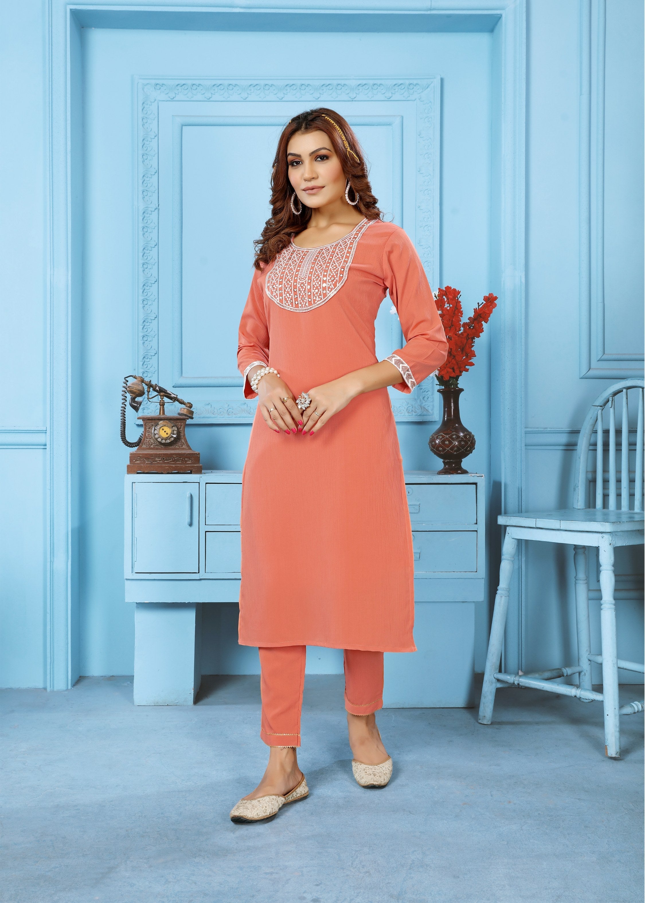 Women wearing an orange Rinkal cotton embroidered kurta set with matching bottom