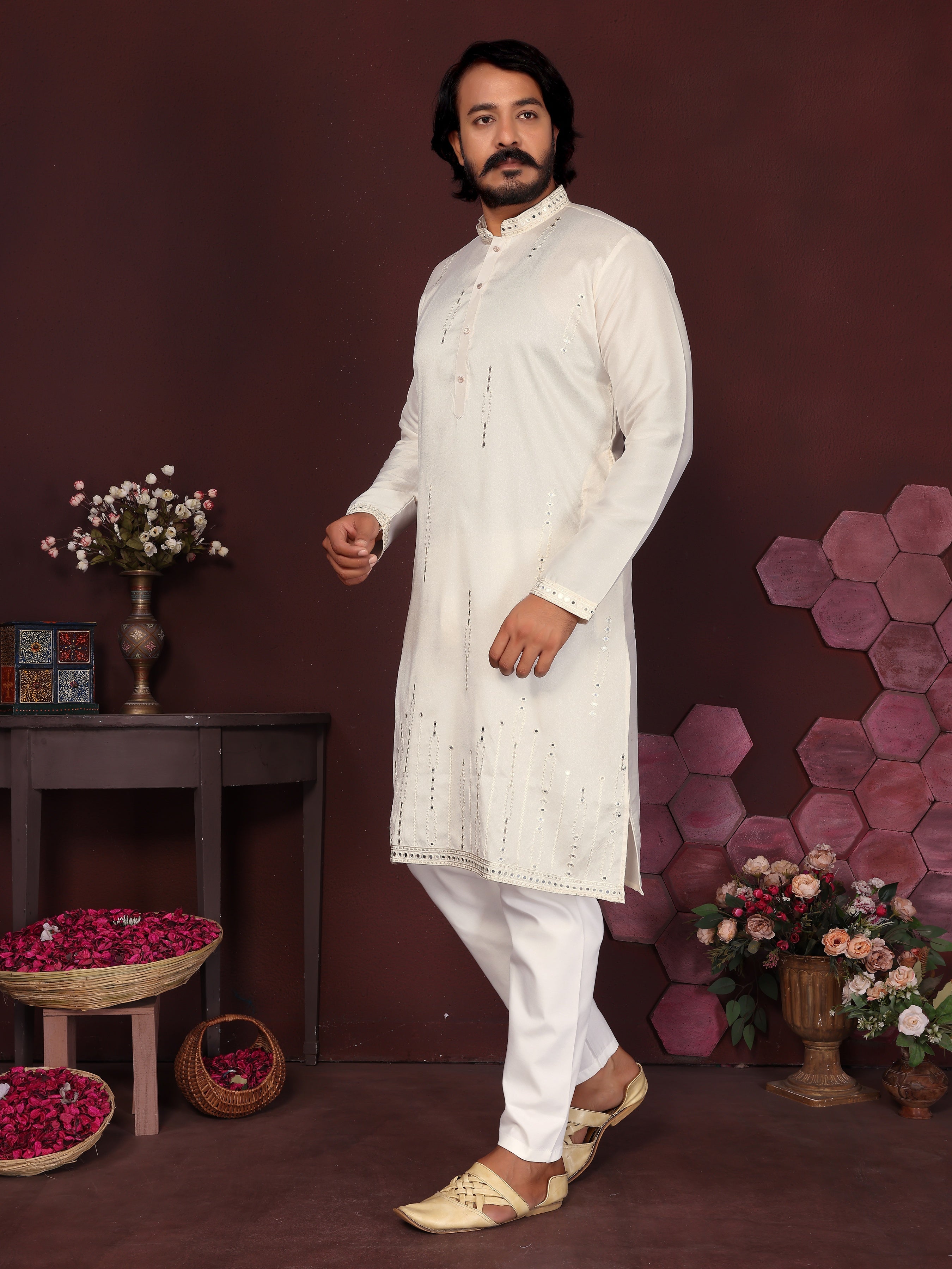 Toddler boy wearing a white knee-length kurta with mirror embroidery and matching trousers
