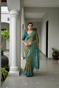 Close up of a mehendi colored soft tussar silk saree with detailed ikkat prints