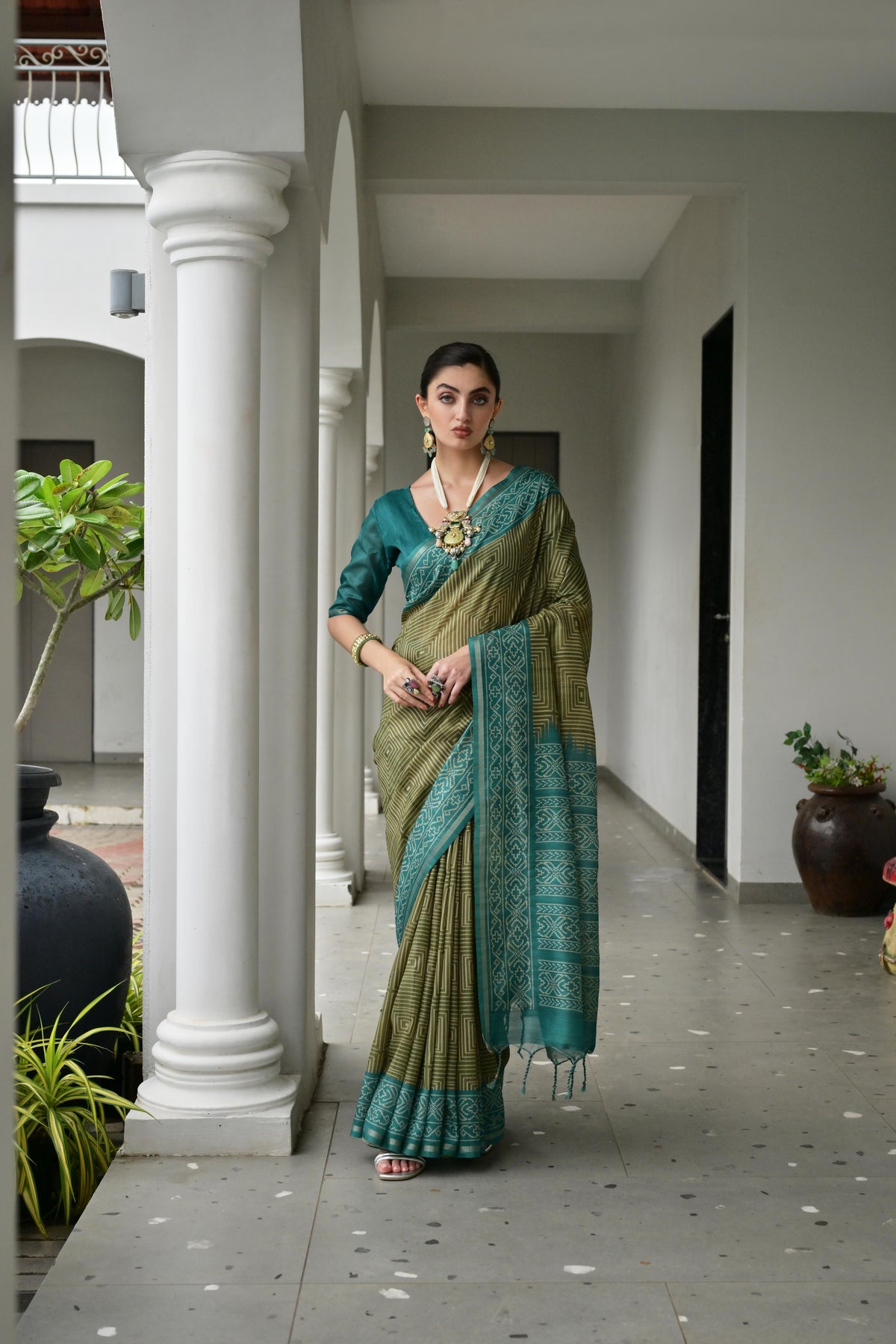 Close up of a mehendi colored soft tussar silk saree with detailed ikkat prints