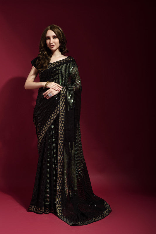 Woman wearing a black georgette saree with intricate sequence embroidery and a matching blouse.