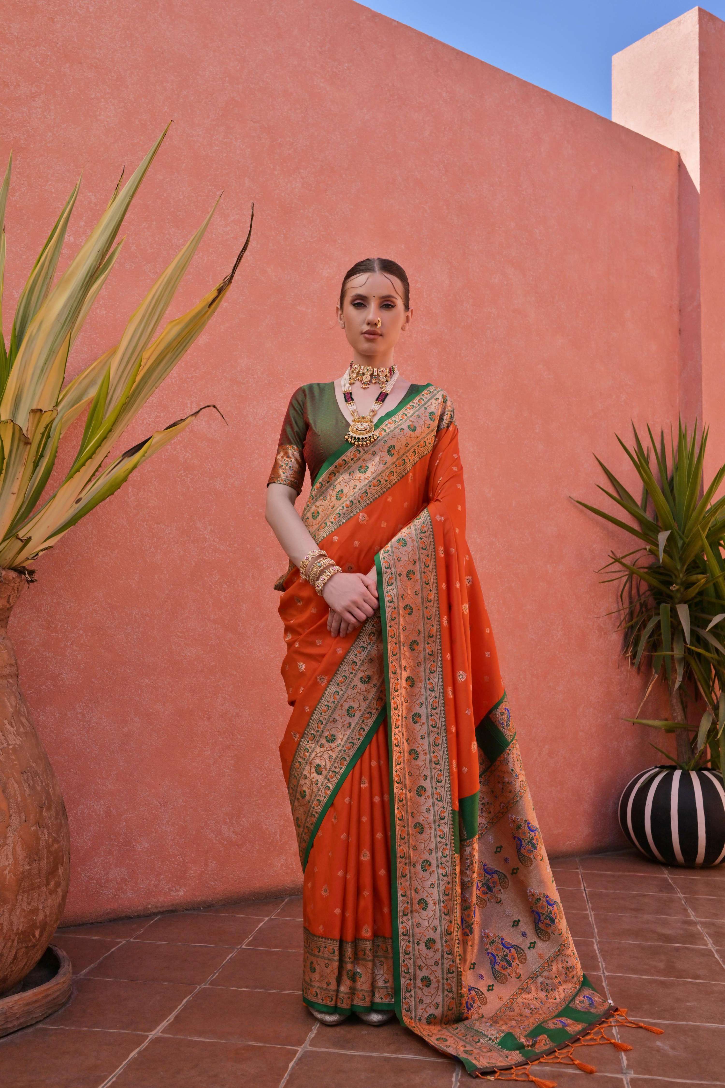 Orange Paithani silk saree with intricate gold zari woven details and matching blouse piece.