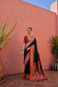 Woman wearing a black Paithani silk saree with intricate gold zari woven details and an unstitched blouse piece.