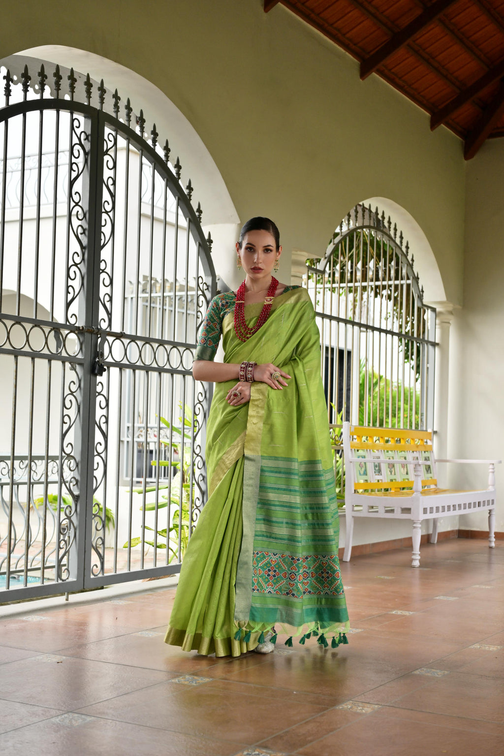 Green Khadi raw silk saree with traditional Meena weaving and Patola-inspired pattern.