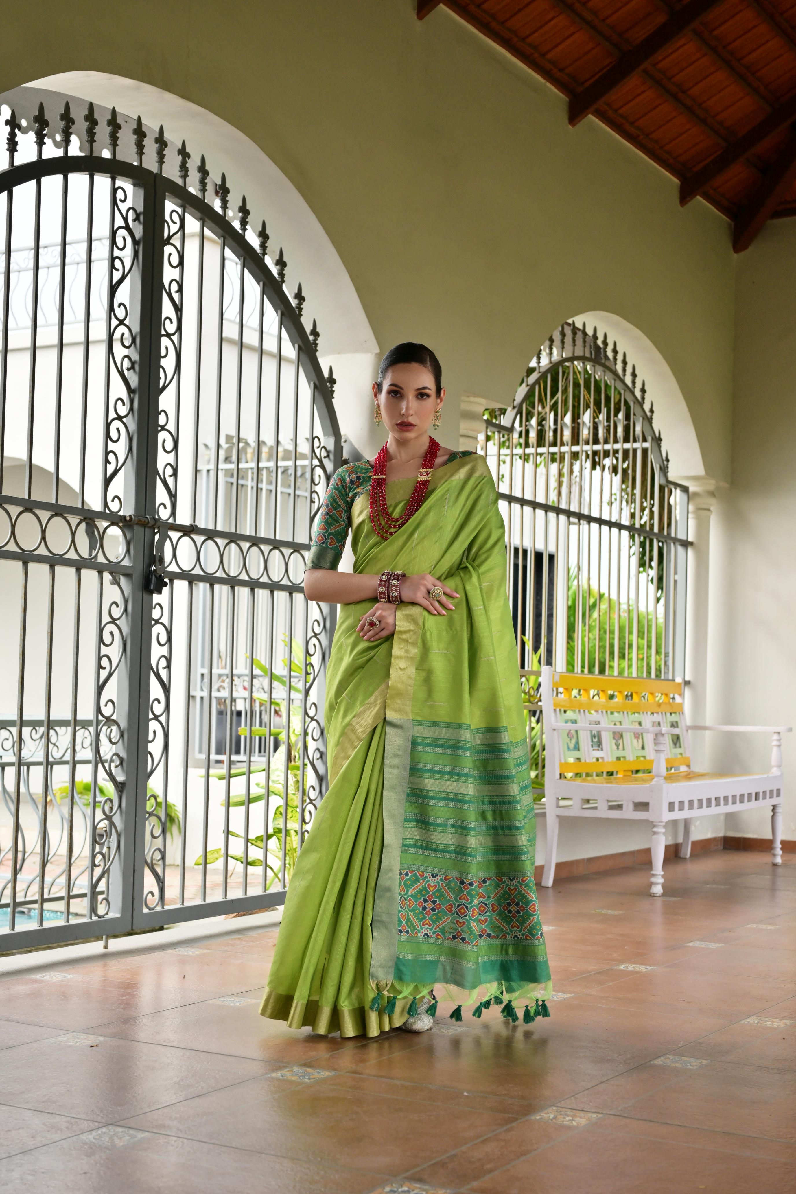 Green Khadi raw silk saree with traditional Meena weaving and Patola-inspired pattern.