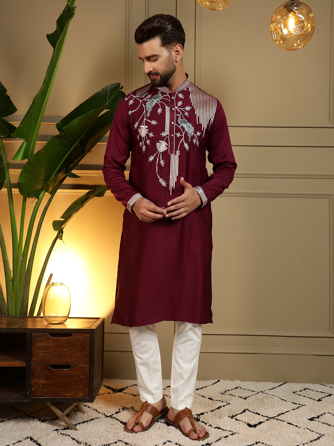A front view of a maroon men's kurta with detailed sequins embroidery paired with a matching pajama.