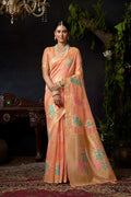 Peach organza khadi saree with gold zari weaving and decorative jhalar border.