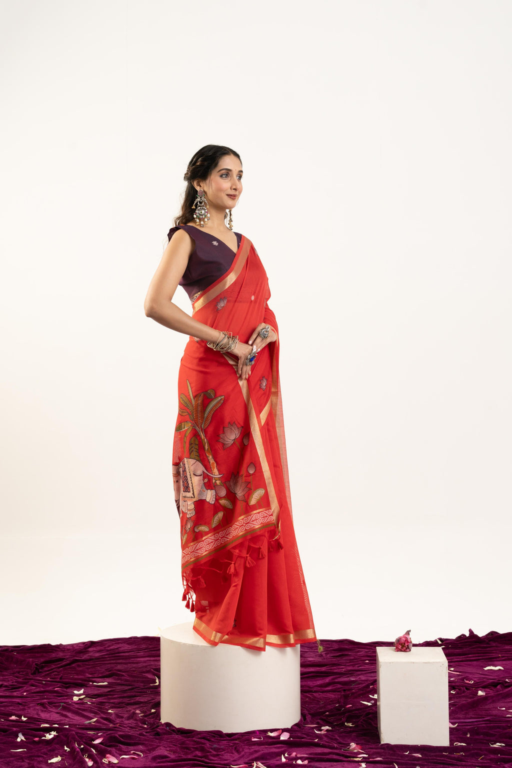 A beautiful red soft Muga cotton saree with intricate Zari woven butties and an unstitched blouse piece.