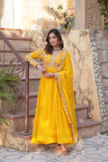 Woman wearing a yellow Faux Blooming Anarkali set with detailed zari and sequins embroidery.