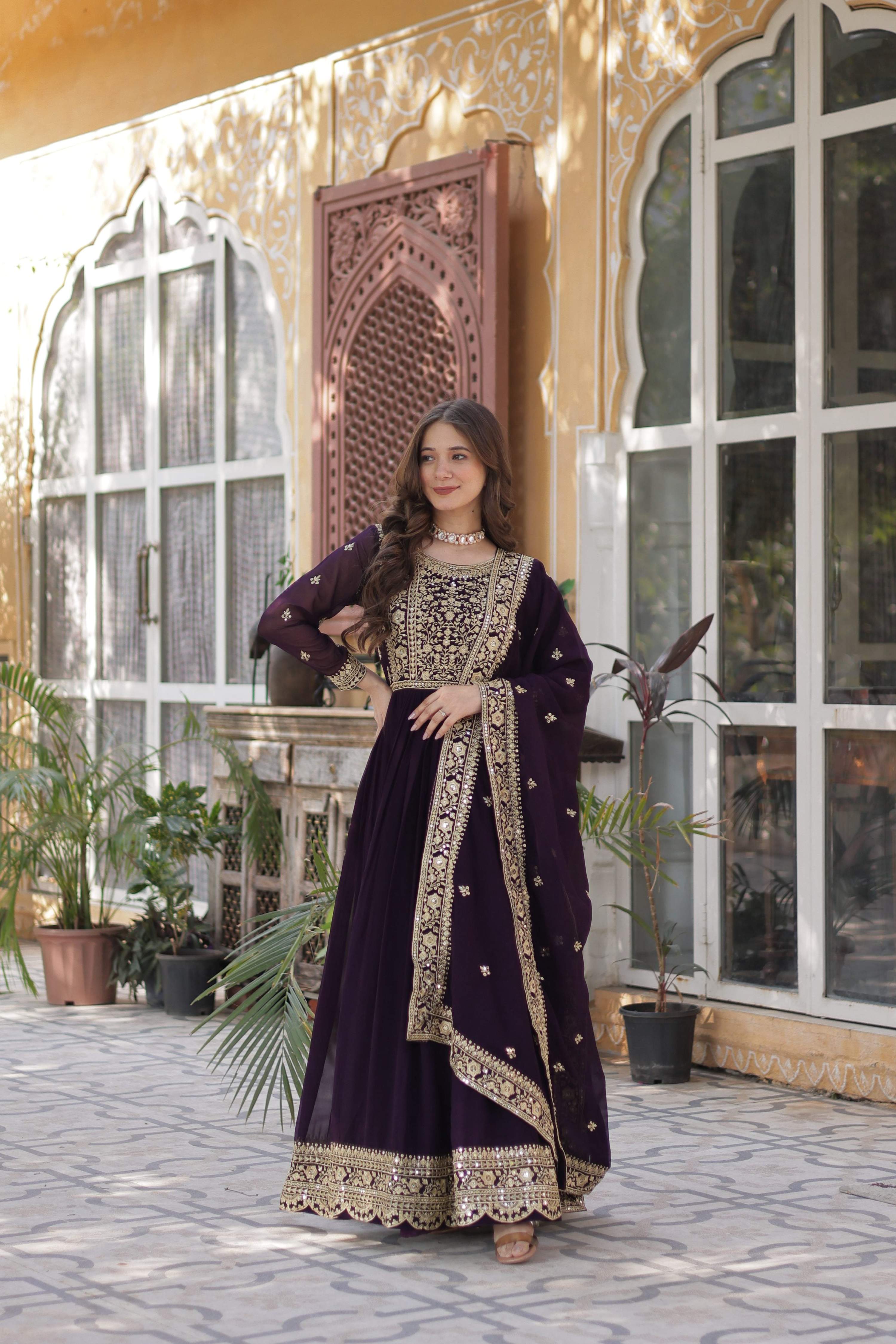 Model wearing a wine-colored Faux Blooming Anarkali set with gold zari embroidery and matching dupatta