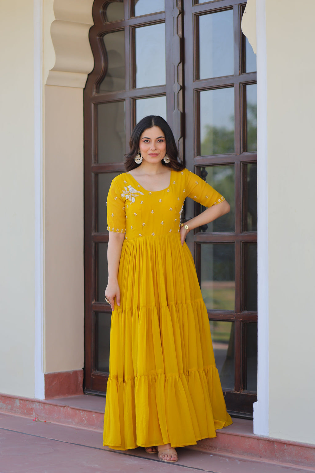 Model wearing a vibrant yellow Faux Blooming Anarkali set with detailed bead embroidery and a wide flair.