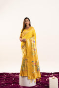 A vibrant yellow Banarasi silk saree with detailed gold zari weaving, shown with matching unstitched blouse fabric.