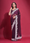 A beautiful wine-colored georgette saree with detailed coding work and a matching blouse.